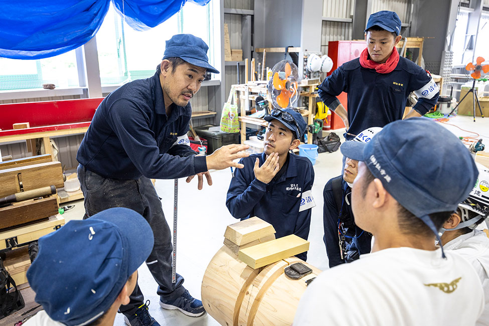 先輩から後輩へ技術を伝えている様子
