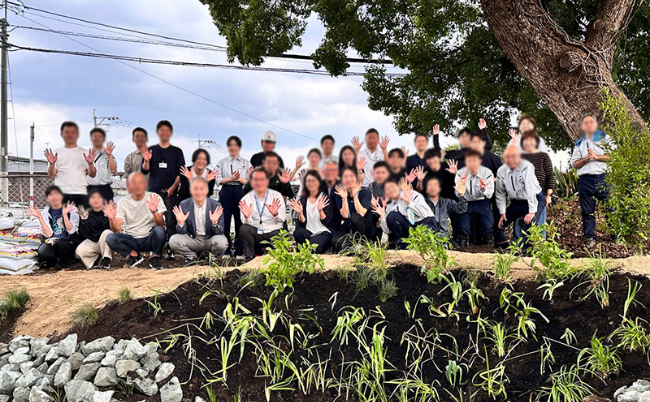 完成した雨庭の前で記念撮影するメンバー