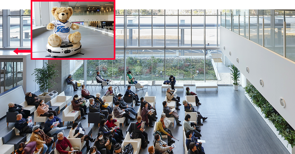 Vacuuming robot ridden by a teddy bear vacuums the roof of the windbreak room in the waiting hall.