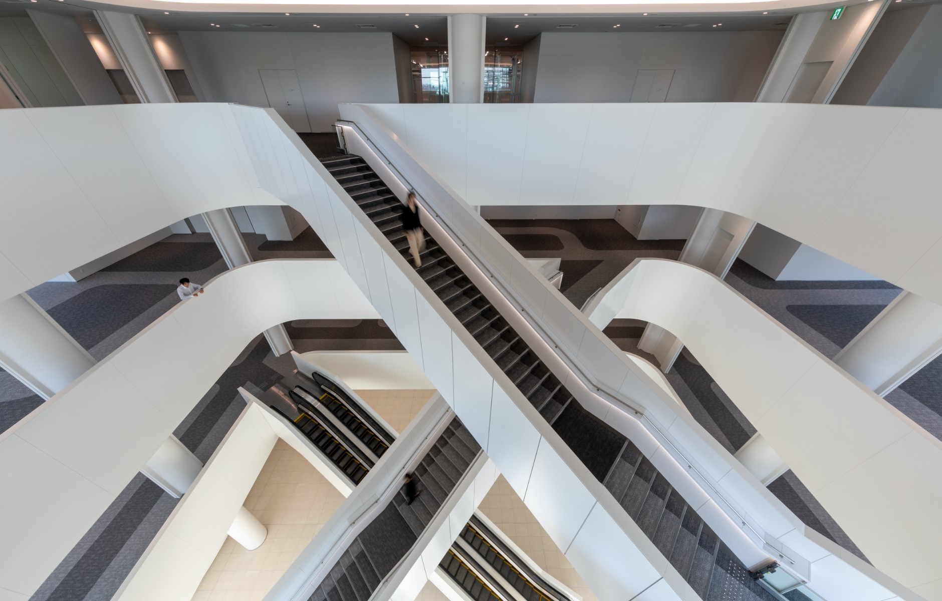 Escalators and stairways criss-cross the atrium, beckoning the visitor inward for an aesthetic journey.