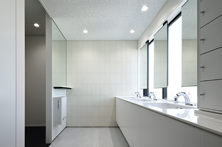 A bathroom awash in light streaming in from the outside. It is equipped with lockers where employees can store make-up bags and other small items.