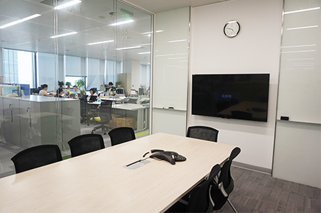 A sound-insulated meeting room in the center of the office. A glass partition was used to allow external lighting in, creating a sense of spaciousness.