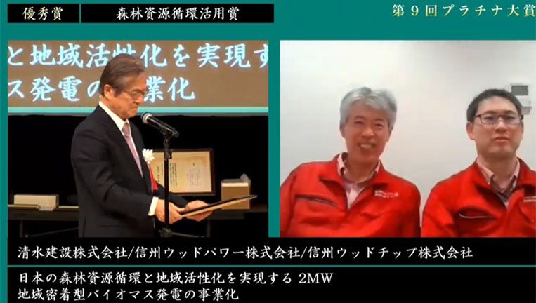 表彰状を授与するプラチナ構想ネットワーク小宮山会長と優秀賞受賞者の信州ウッドパワー（株）・信州ウッドチップ（株） 陰山社長と当社の武田匡史