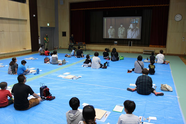 東京木工場と現地をオンラインで中継