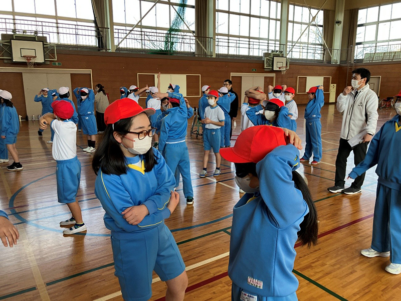 アイマスクを付けた相手に言葉でポーズを伝える練習の写真