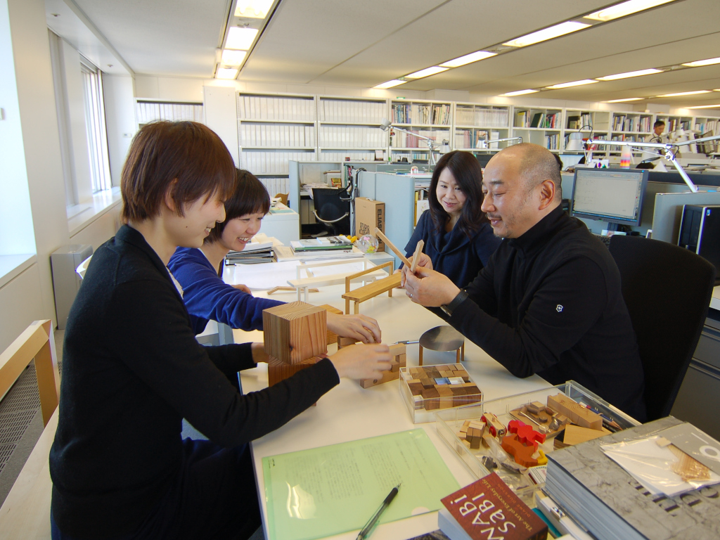 Mr. Shimura and his younger colleagues at Field Four Design Office discuss planning with models