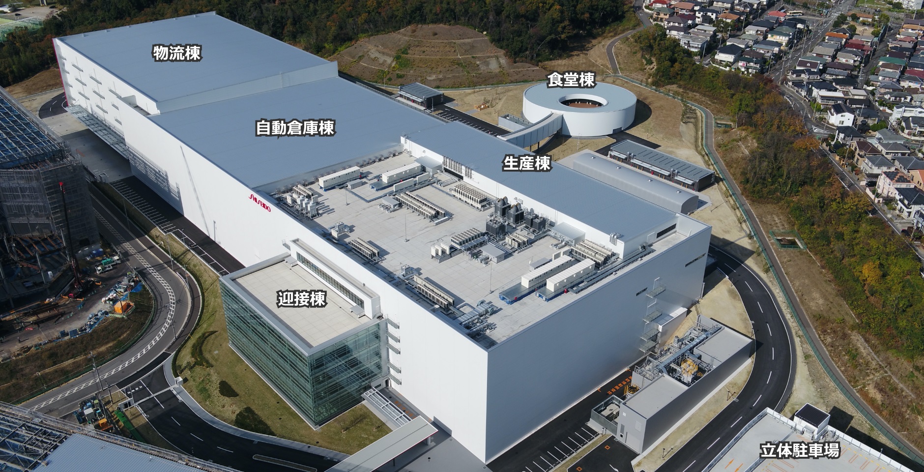 生産棟、自動倉庫棟、物流棟を1棟化した資生堂の大阪茨木工場。手前の迎接棟と奥の食堂棟では高低差が13.5ｍある