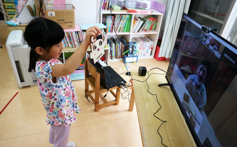 画面の向こうの先生に作品を見せる園児